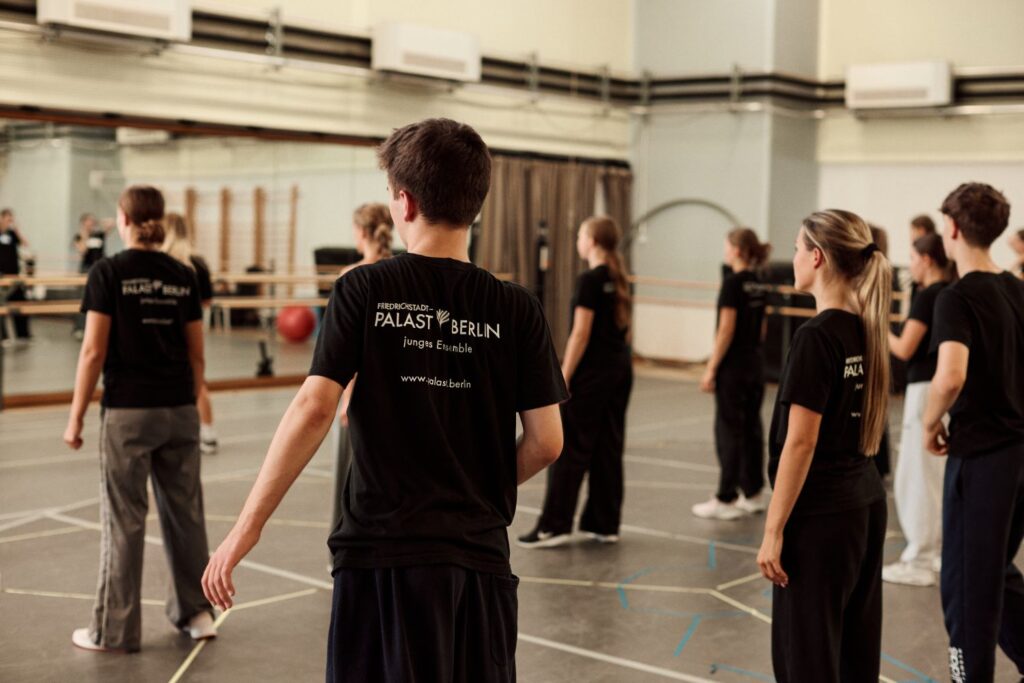 Gruppe junger Menschen in schwarzen Tshirts in einem Ballettsaal
