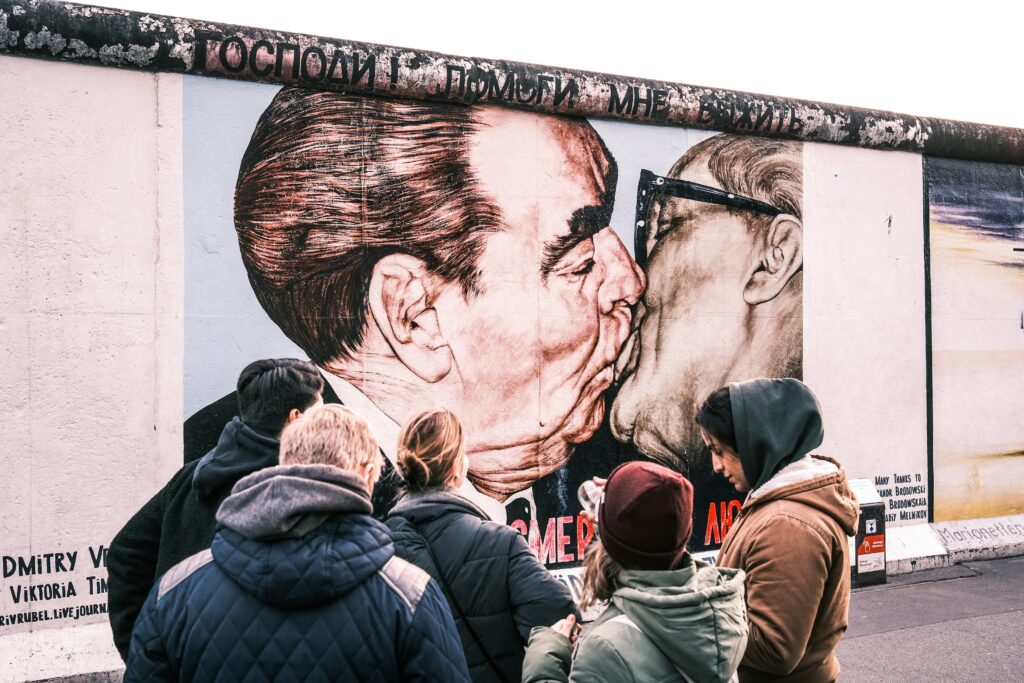 Ausschnitt der Berliner Mauer von zwei küssenden Männern
